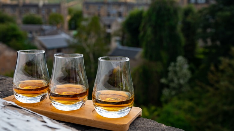 Three whiskey drinks on windowsill