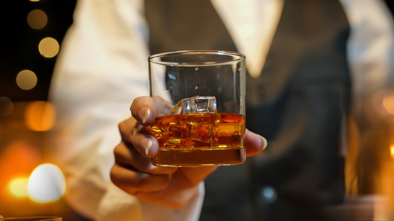 Bartender serving a glass of whiskey