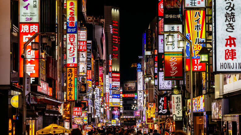 Tokyo city exterior at night with many illuminated signs.