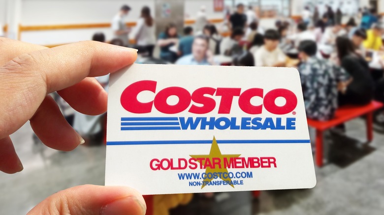 closeup of a Costco card in a person's hand inside Costco