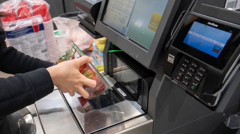 woman scanning strawberries at costco checkout