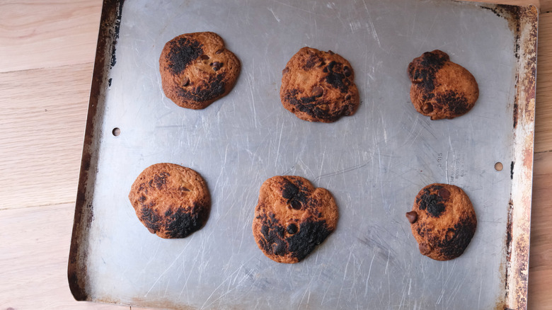 Burnt chocolate chip cookies on a baking sheet