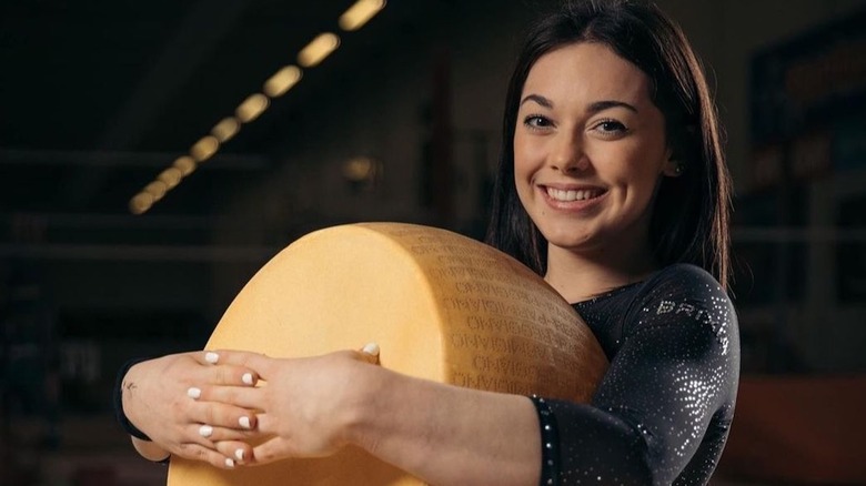 Giorgia Villa holding a wheel of parmesean