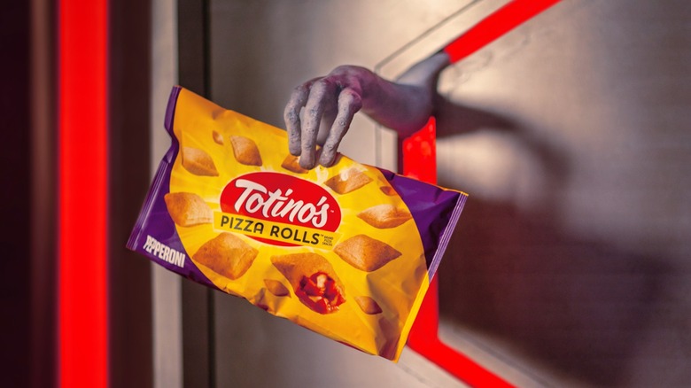 Chazmo's alien hand shut in door holding Totino's Pizza Rolls package