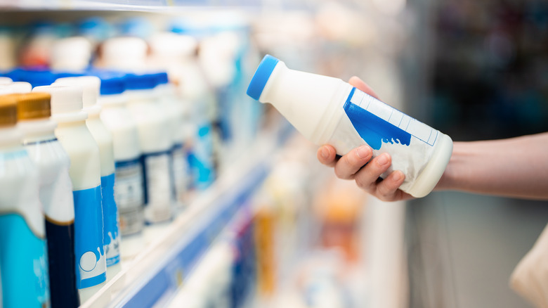 Person holding milk in store