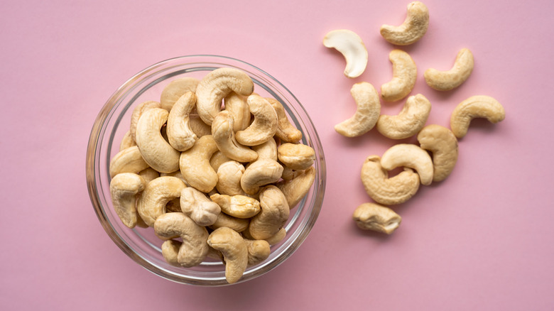 Bowl of cashews pink background