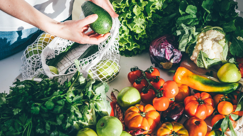 woman removing fresh vegetables from bag