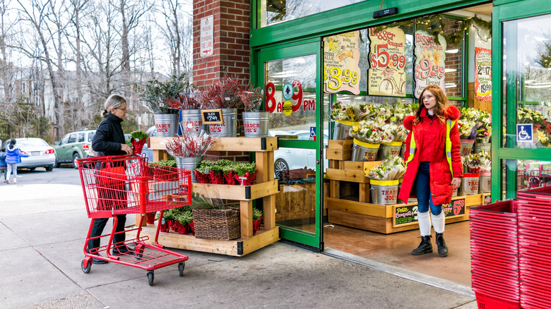 woman picking out a plant outside trader joe's