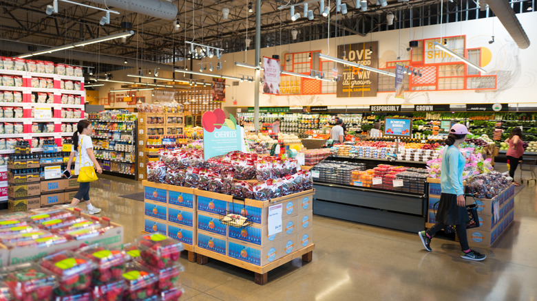 shoppers inside a whole foods surrounded by groceries