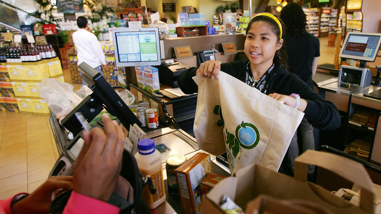 whole foods employee giving out free reusable shopping bag