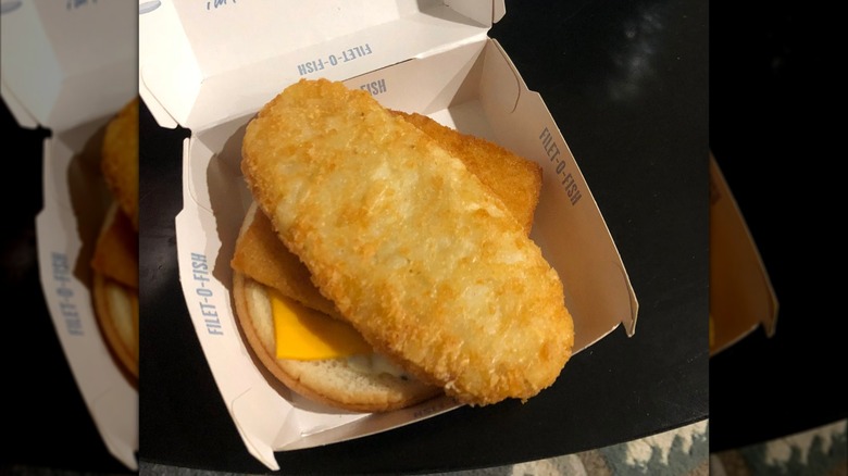 Filet-O-Fish sitting in box, with a hash brown inside it