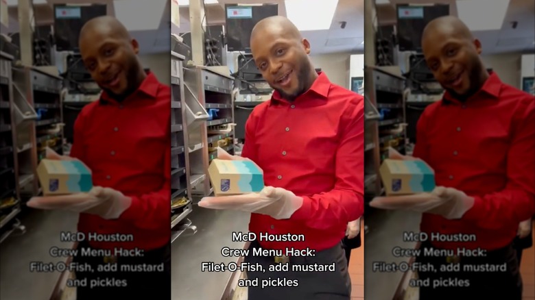 McDonald's employee holding up boxed Filet-O-Fish, with caption superimposed on image: "McD Houston Crew Menu Hack: Filet-O-Fish, add mustard and pickles"