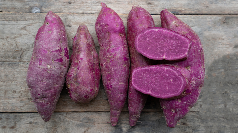 Okinawan purple sweet potatoes on wooden surface.