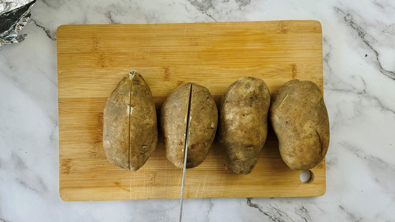 sliced cooked potatoes with knife