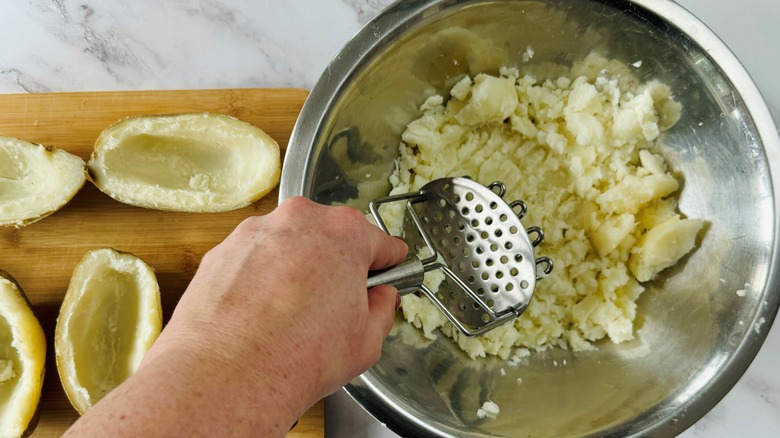 hand mashing cooked potato