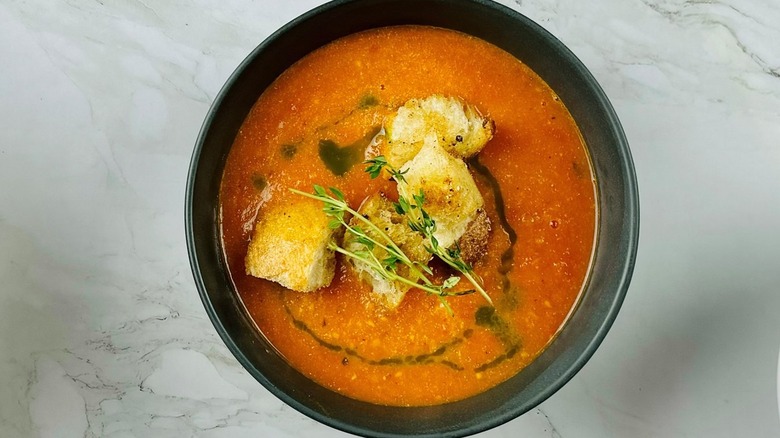 tomato soup with croutons in a black bowl