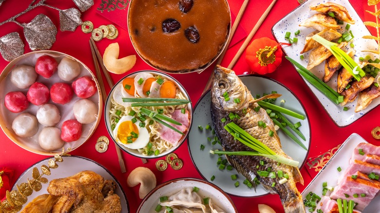 Traditional Chinese New Year dishes like dumplings, rice cakes, whole fish, and noodles.