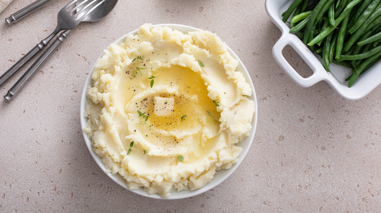 A bowl of mashed potatoes topped with melting butter