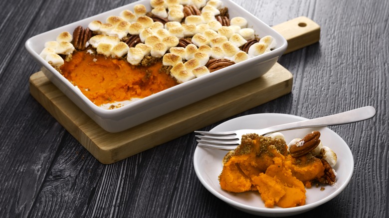 A plate of sweet potato casserole with one serving on a plate