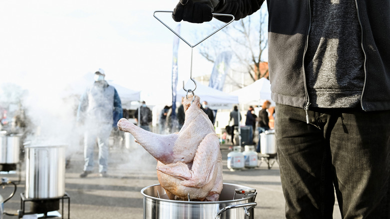 turkey lowered into deep fryer