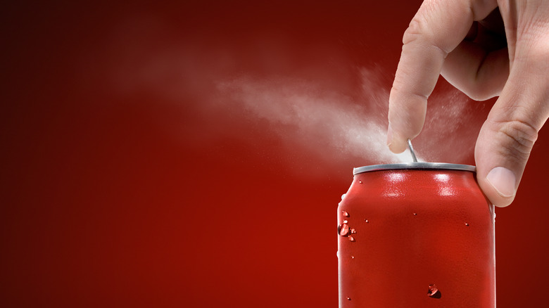 Opening a can of soda with fizz