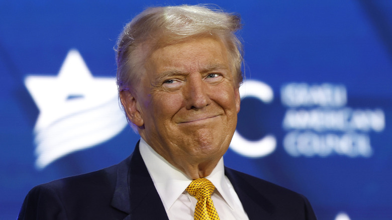 Donald Trump with a yellow tie smiling