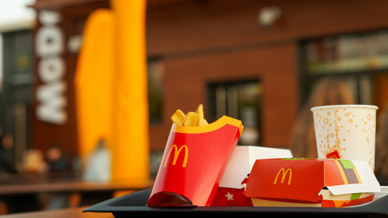 McDonald's fries, burger and drink on a tray in front of the restaurant