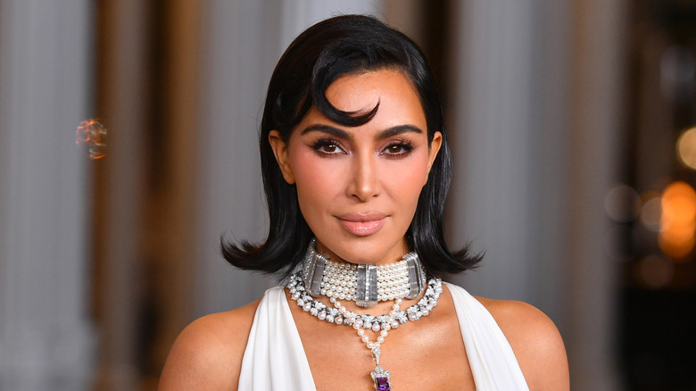 Kim Kardashian wearing pearls and a white halterneck dress