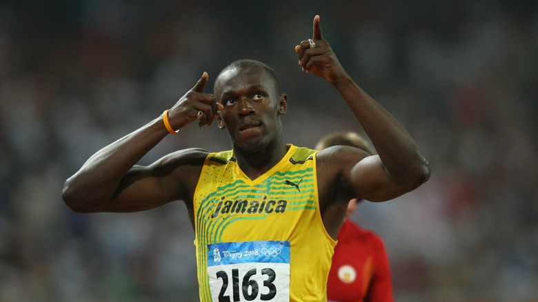 Usain Bolt in a yellow track jersey pointing to the sky