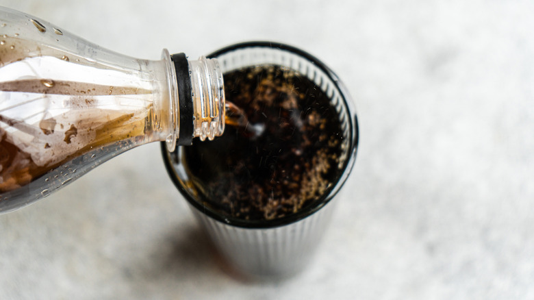 A cola being poured into a glass.