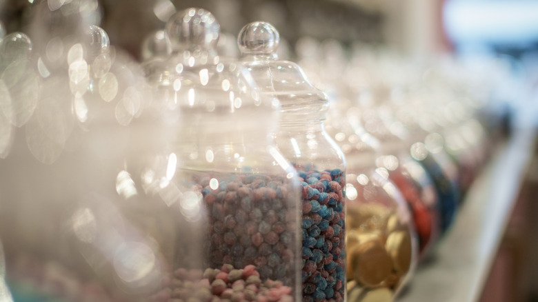 Jars of brightly colored candy in a row