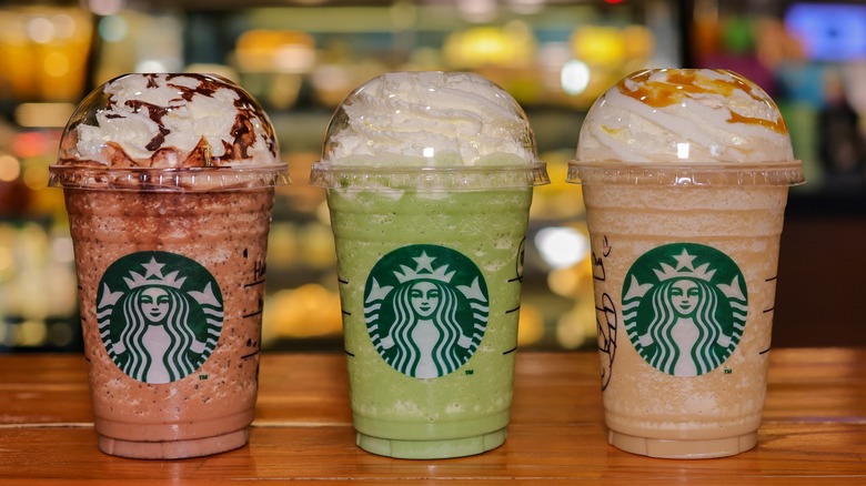 Three Starbucks handcrafted drinks on wood table