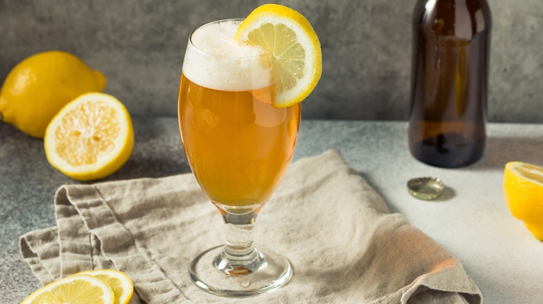 Shandy beer cocktail with lemon wedge