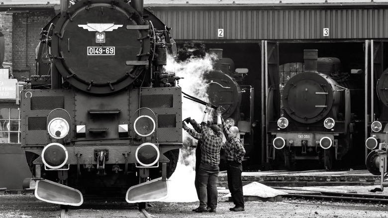 Steam engine workers near train