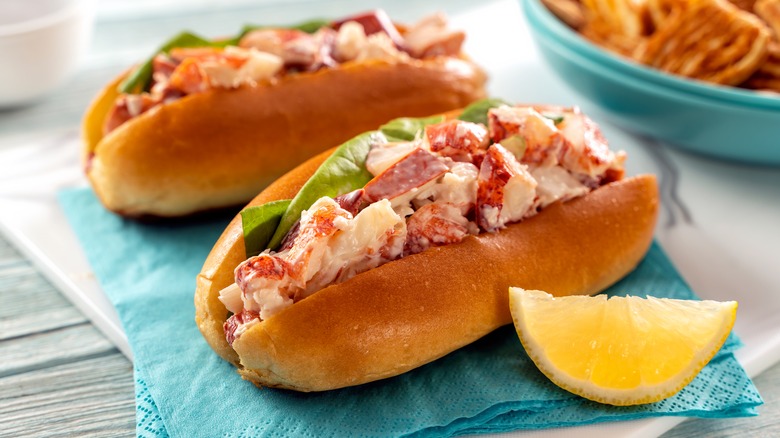 Two lobster rolls on blue cloth