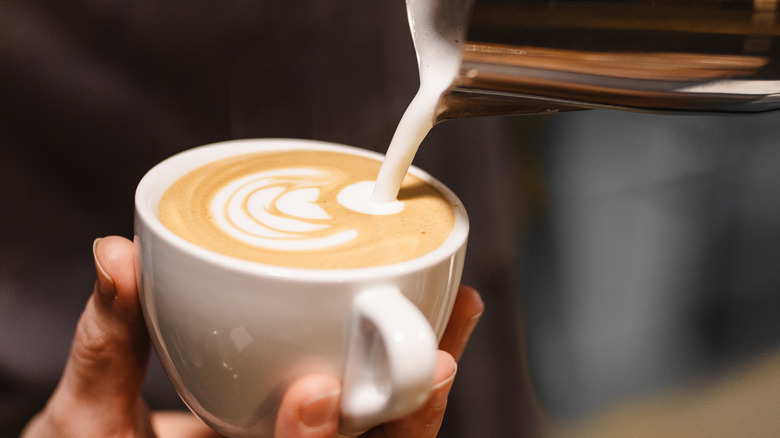 Steamed milk pouring into latte