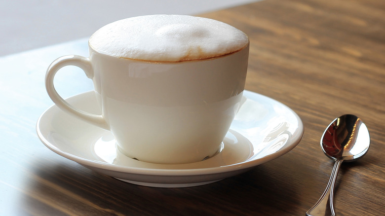 Cappuccino with milk foam in white mug