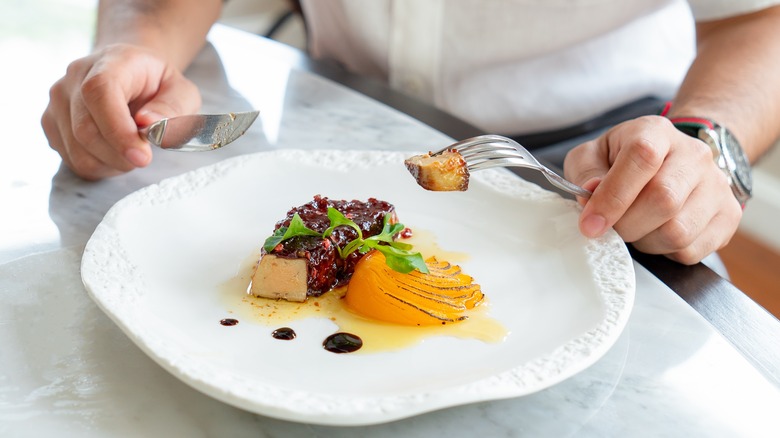 person cutting foie gras