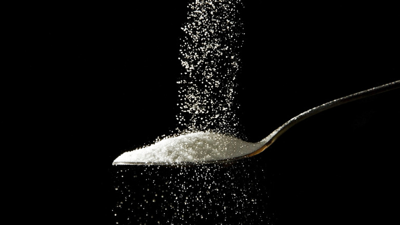 Sugar falling onto metal spoon