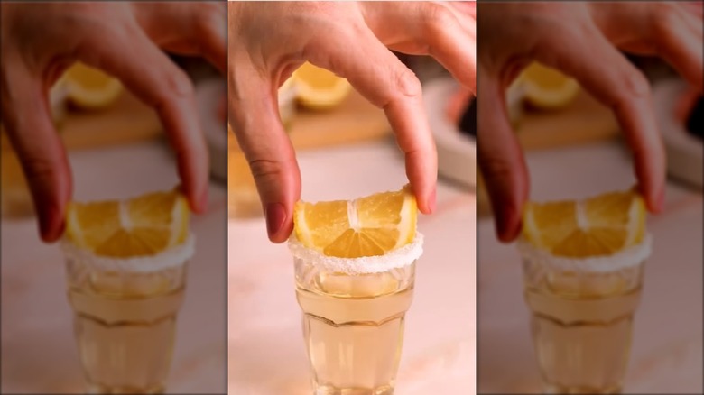 A hand places a lemon on a German chocolate cake shot