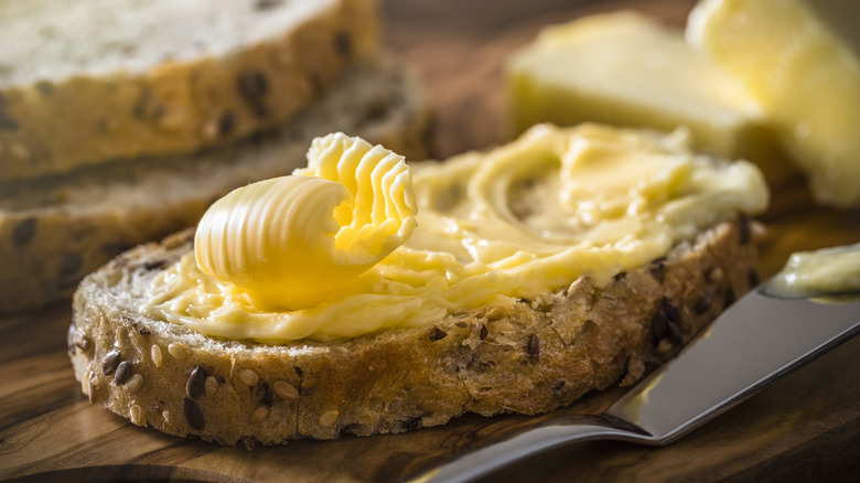 Yellow butter spread on a slice of bread.