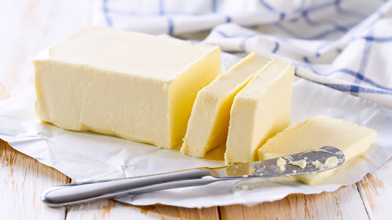 Stick of butter sliced with butter knife.