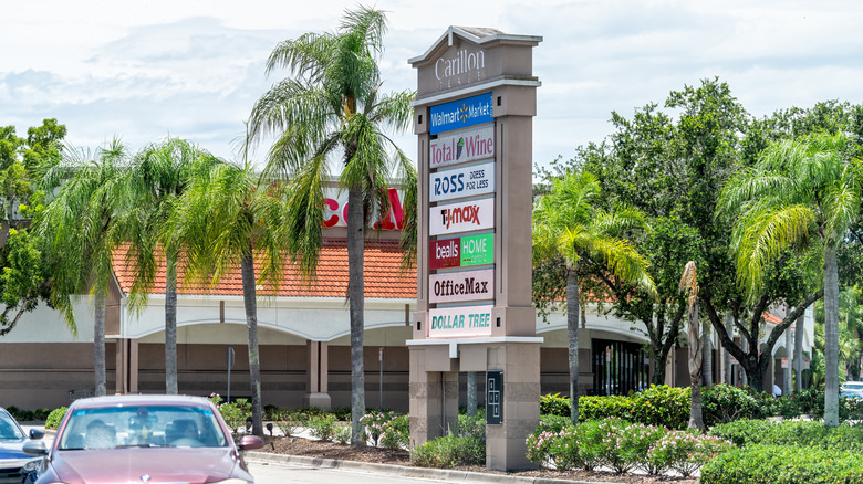 A sign displaying the name of several large stores in a plaza