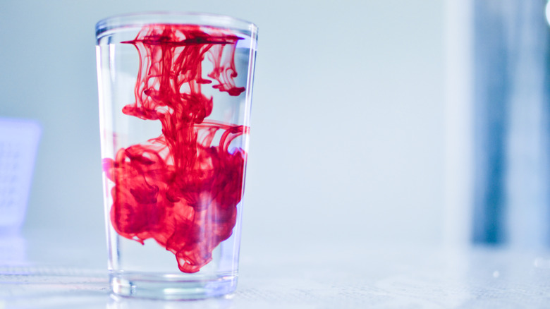 Red dye diffuses into a glass of water