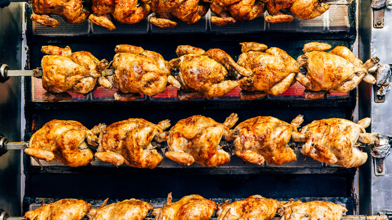 rotisserie chickens being cooked on a rotisserie