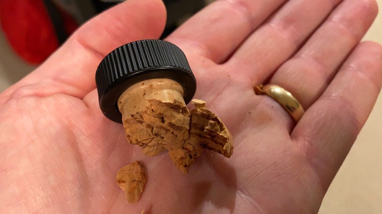 Broken cork in hand