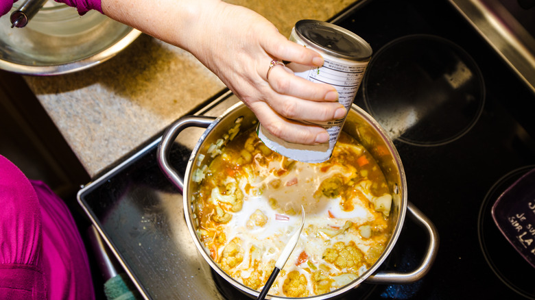 preparing can of soup on stove