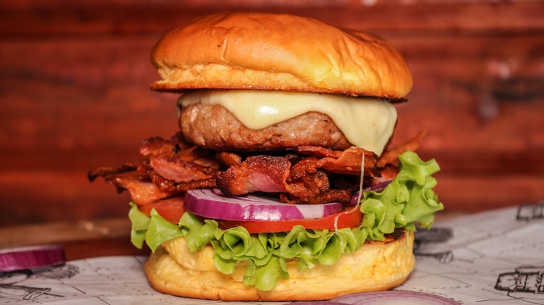 Burger with alligator meat, bacon, cheese, and veggies