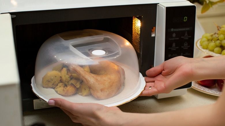 Covered food being put in microwave oven