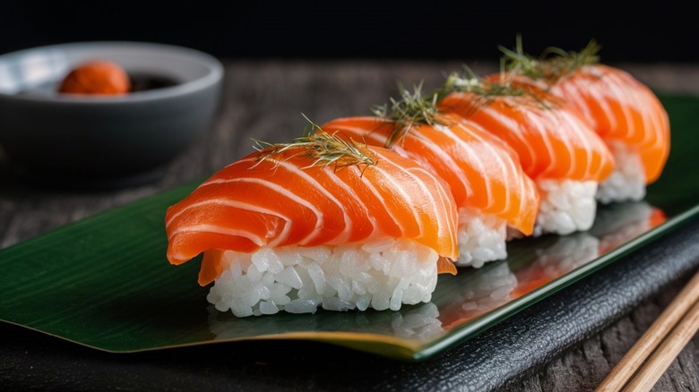 Sushi salmon on plate with chopsticks nearby